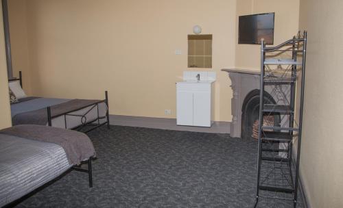 a small room with a bed and a television at Hotel Cessnock in Cessnock