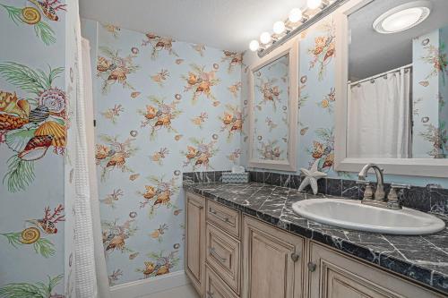 bagno con lavandino e carta da parati floreale di Sonrisa Unit-3/ Lovely Condo , 2 Bedrooms-2Baths a Clearwater Beach