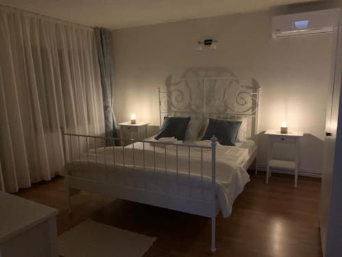 una camera da letto con un grande letto bianco con due comodini di Pensiunea Valea Șușiței, Ciubar, Sauna, ATV, Safarii Jepp Offroad Ghid Turistic, Climbing, Rafting, Paragliding a Târgu Jiu