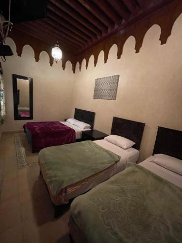 een kamer met drie bedden in een kamer bij Hotel Cecil in Marrakesh