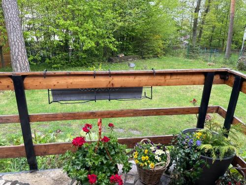 a balcony with flowers and a bench in a park at Wooden house in the nature in Modra