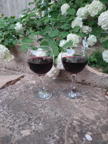 two glasses of red wine sitting on a table at Guesthouse TEA in Kutaisi