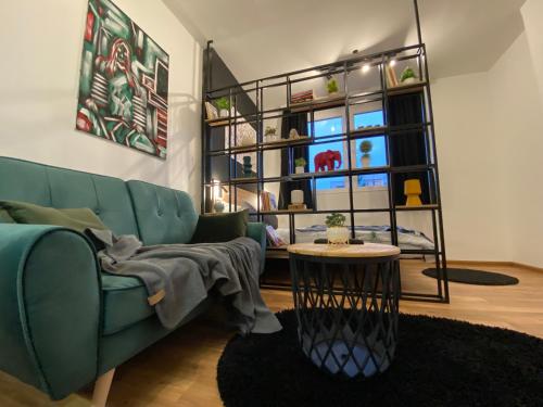 a living room with a green couch and a table at Mickitos Modern & Cozy Studio in Skopje