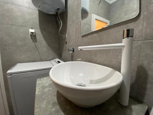 a bathroom with a white sink and a mirror at Mickitos Modern & Cozy Studio in Skopje