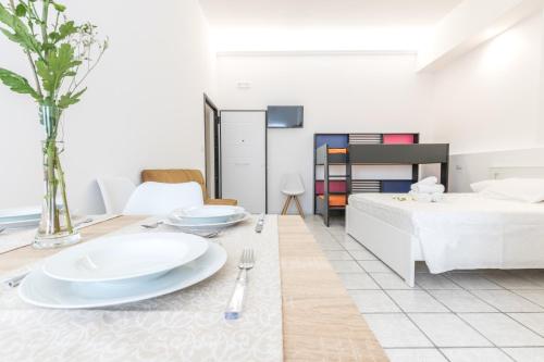 a living room with a bed and a table with plates at La Gemma del Salento Rooms&Apartments in Racale