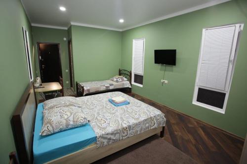 a bedroom with a bed and a tv in it at John’s in Sukhum