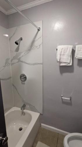 a white bathroom with a tub and a sink at TOCCOA MOTEL in Toccoa