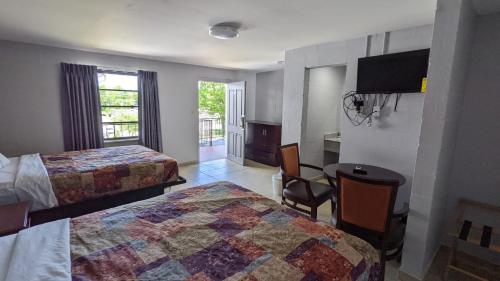 una camera d'albergo con due letti e una televisione di TOCCOA MOTEL a Toccoa