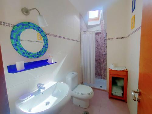 a bathroom with a sink and a toilet and a mirror at Ático Cool Isla de Arousa in Isla de Arosa