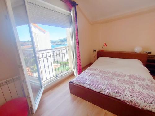a bedroom with a bed and a large window at Ático Cool Isla de Arousa in Isla de Arosa
