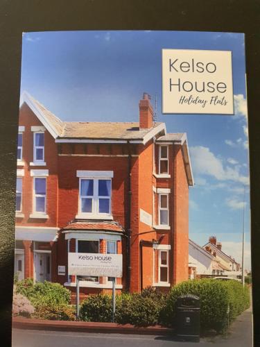 a brick house with a sign in front of it at Kelso House holiday flats in Blackpool