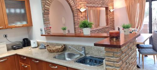 a kitchen with a sink and a brick wall at 'The Seagull' Traditional Cottage in Nea Makri