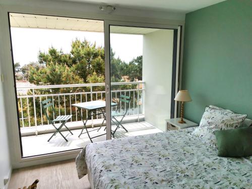 une chambre avec un lit et une vue sur un balcon dans l'établissement Le Colombier, à Les Sables-dʼOlonne