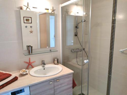 une salle de bain avec un lavabo et une douche dans l'établissement Le Colombier, à Les Sables-dʼOlonne