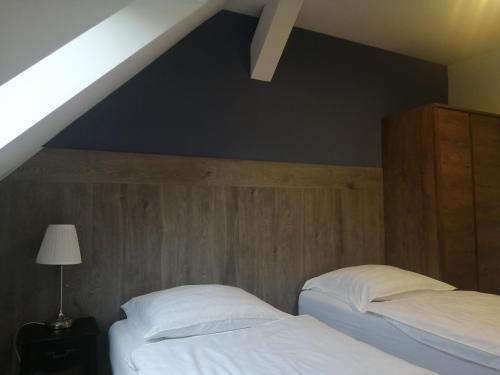 two beds in a bedroom with a roof at Filsdeger Ház - Central Rooms & Apartmans in Eger