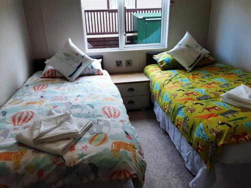 two beds sitting next to each other in a bedroom at Coastal View in Brixham