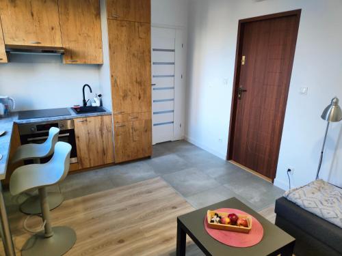 a kitchen and a living room with a bowl of fruit on a table at Giżycko in Giżycko