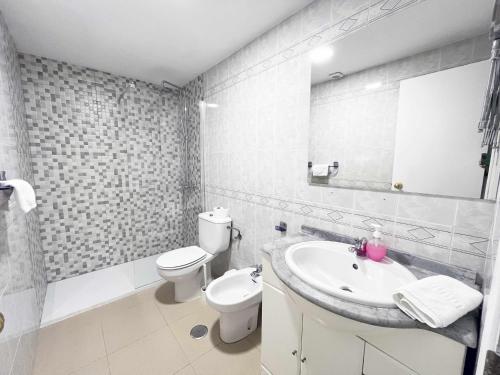 a bathroom with a sink and a toilet and a mirror at Mshome Mirada al Mediterráneo in Rincón de la Victoria