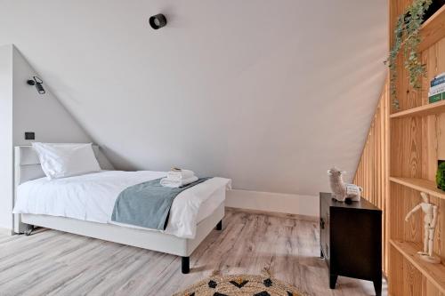 a bedroom with a white bed and a wooden floor at Harda House Friends & Spa in Zakopane