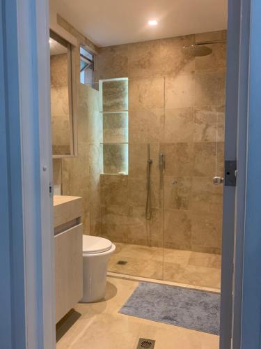 La salle de bains est pourvue de toilettes et d'une douche en verre. dans l'établissement Morros 3 - Vista y salida directa al mar, à Carthagène des Indes