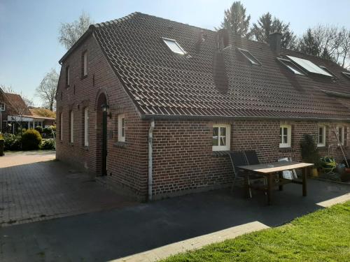 uma casa de tijolos com uma mesa em frente em Ferienwohnung Rendelchen em Großheide