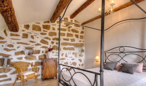 - une chambre avec un lit et un mur en pierre dans l'établissement Gîte à Piscia de Figari Petru Barbara, à Figari