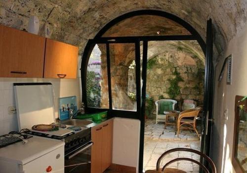 a kitchen with an archway leading to a patio at Classique Cavtat Apartment in Cavtat