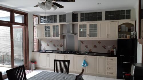 a kitchen with white cabinets and a table with chairs at Casa Bella in Bogor