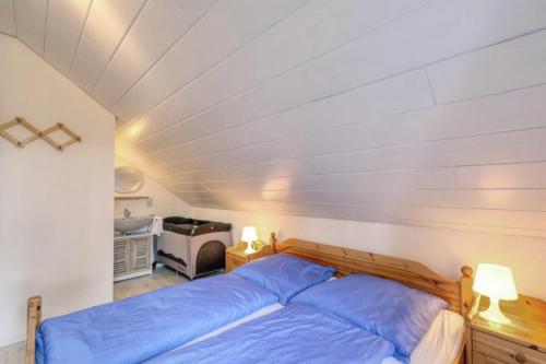 a bedroom with a bed with blue sheets at Seepark Kirchheim Ferienhaus bei Zeta mit Sauna in Kirchheim