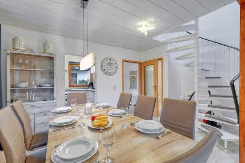 a dining room with a table and chairs and a staircase at Seepark Kirchheim Ferienhaus bei Zeta mit Sauna in Kirchheim