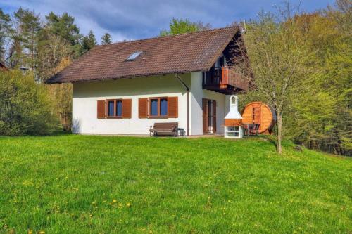 a small white house with a green yard at Seepark Kirchheim Ferienhaus bei Zeta mit Sauna in Kirchheim