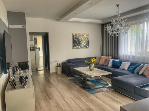 uma sala de estar com um sofá azul e uma mesa em Modern 2 bed house near Bratislava with parking em Rovinka