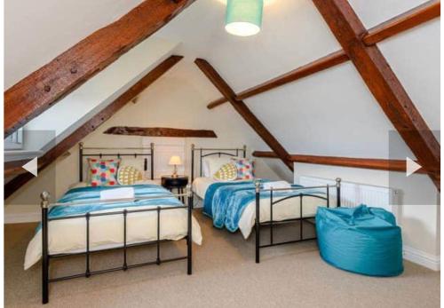 two beds in a attic room with wooden beams at West Cottage. Central, beautiful, 2 mins to beach. in Cromer