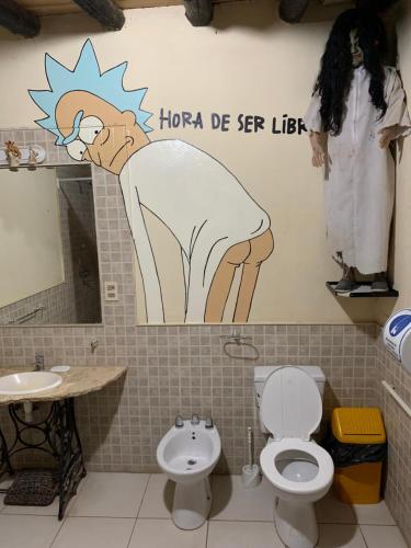 a bathroom with a toilet and a sign on the wall at Lemon Tree Hostel in Vistalba