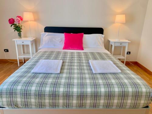 1 cama grande con almohada rosa y 2 mesas en Casa Beraldini, en Verona