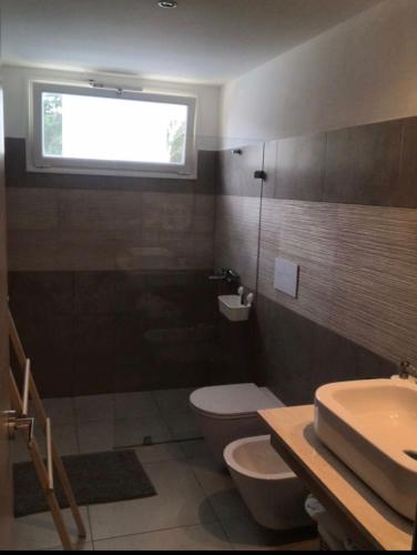 a bathroom with a toilet and a sink and a window at Sunny garden in La Laguna