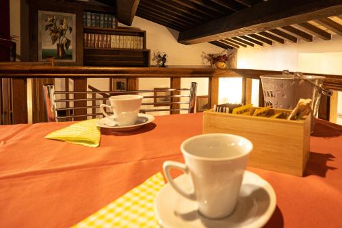 a table with two cups and a box on it at Book and Bed in Orvieto