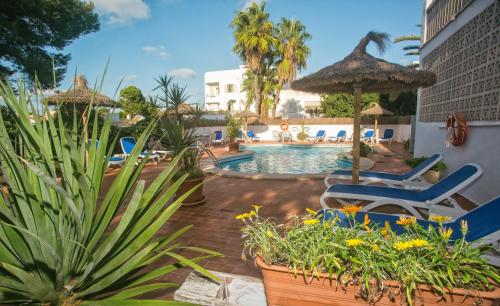 a pool at a resort with chairs and plants at Hotel Martorell in Colonia Sant Jordi