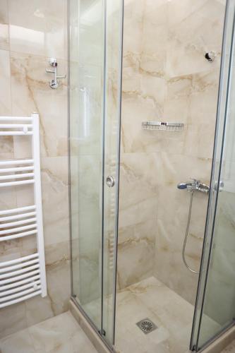 a bathroom with a shower with a glass door at Catherine's Comfort Apartment No1 in Lavrio