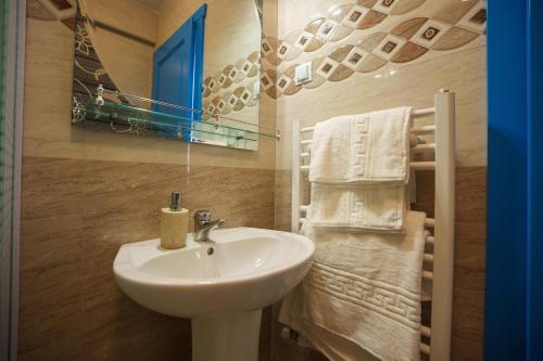 a bathroom with a sink and a mirror and towels at Pensiunea Dolosman in Jurilovca