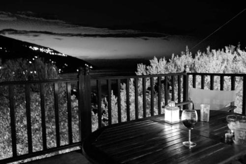 een tafel met een glas wijn op een terras bij Perivoli in Chorefto