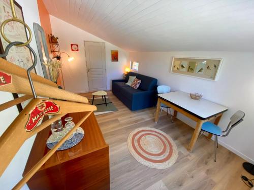 un salon avec un canapé bleu et une table dans l'établissement Chambre de charme indépendante proche Uzès, à Fontarèches