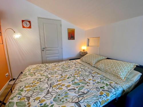 a small bedroom with a bed with a colorful bedspread at Chambre de charme indépendante proche Uzès in Fontarèches