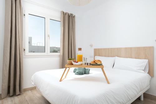 a bedroom with a bed with a tray of food on it at NEW! Apartment ONA 2 with Pool, AC, BBQ, Wifi in Cala D'or, Mallorca in Cala D'or