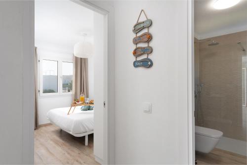 a white room with a bed and a bathroom at NEW! Apartment ONA 2 with Pool, AC, BBQ, Wifi in Cala D'or, Mallorca in Cala D'or
