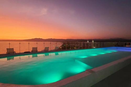 a swimming pool with a sunset in the background at Luxury 2 bedroom beach front at Nuevo Vallarta in Nuevo Vallarta