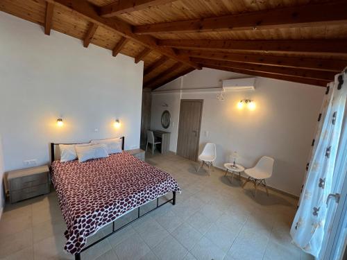 una camera con un grande letto in una stanza con soffitti in legno di Votsalo Luxury Pool Apts a Kalámi