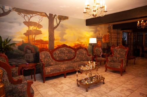 a living room with chairs and a painting on the wall at Hotel Boutique La Mansión Guadalajara in Guadalajara