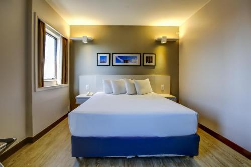 a bedroom with a white bed and white walls at Comfort Suites Brasília in Brasília