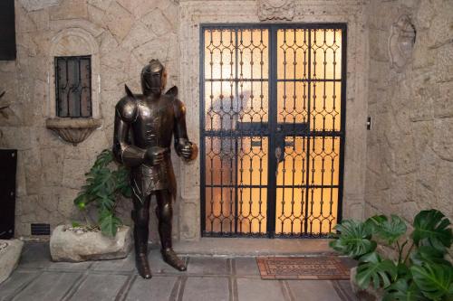 a bronze statue of a man standing in front of a door at Hotel Boutique La Mansión Guadalajara in Guadalajara